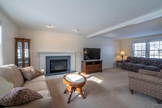 carpeted living area featuring baseboards, beam ceiling, and a fireplace