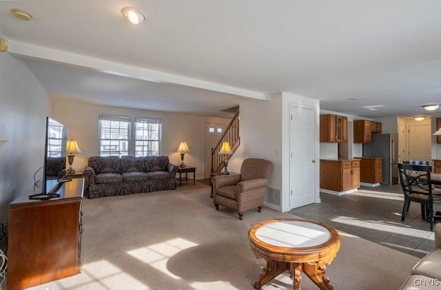 carpeted living room featuring stairs and visible vents