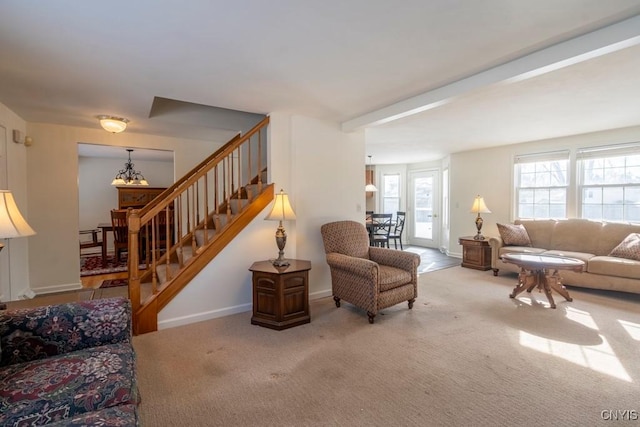 living room with stairs, an inviting chandelier, carpet, and baseboards