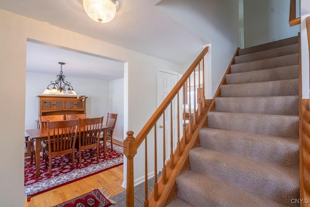 staircase with baseboards and wood finished floors