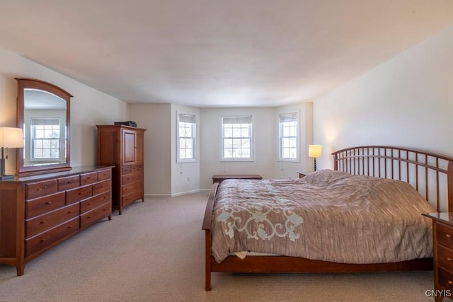 bedroom with baseboards and light carpet