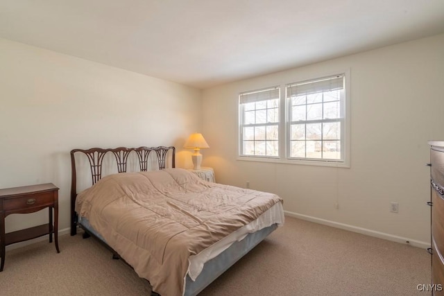 bedroom with baseboards and light colored carpet