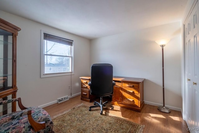 office with visible vents, light wood-type flooring, and baseboards