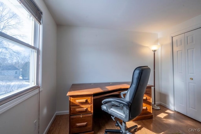 office space with plenty of natural light, wood finished floors, and baseboards