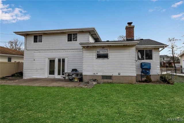 rear view of property featuring a yard, fence, a chimney, and a patio area