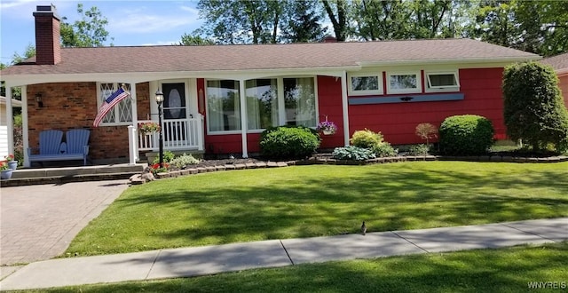 ranch-style home with a front yard, brick siding, and a chimney