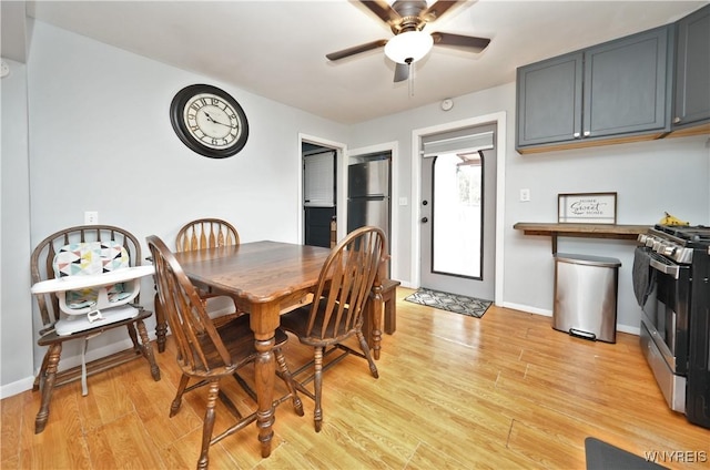 dining area featuring baseboards, light wood finished floors, and ceiling fan