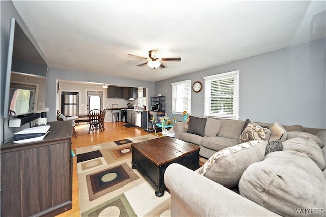 living room with light wood-style floors and a ceiling fan