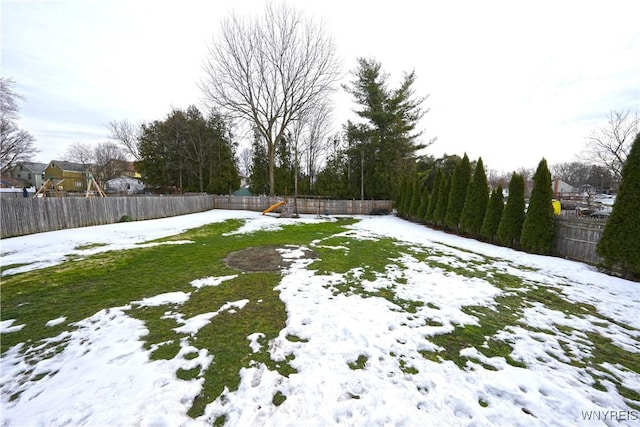 snowy yard with a fenced backyard