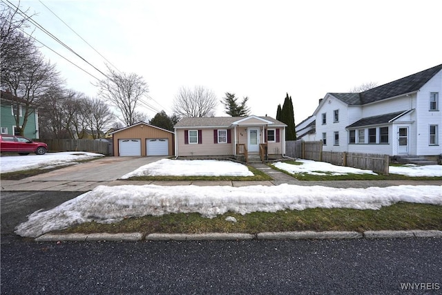 view of front of property featuring a detached garage, an outdoor structure, and fence