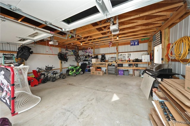 garage with a workshop area, a garage door opener, and metal wall