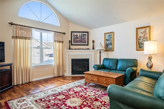 living room featuring baseboards, wood finished floors, a fireplace, and vaulted ceiling