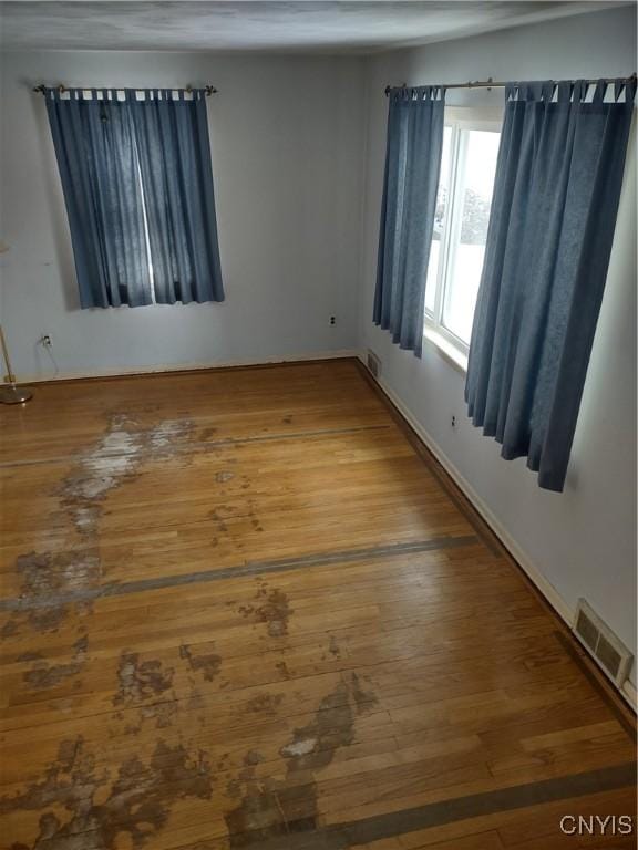 spare room with visible vents and wood finished floors