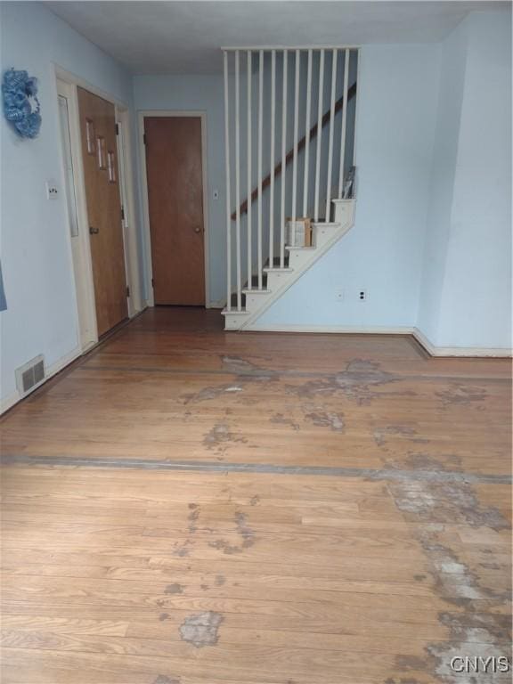 entrance foyer featuring stairway, wood finished floors, and visible vents