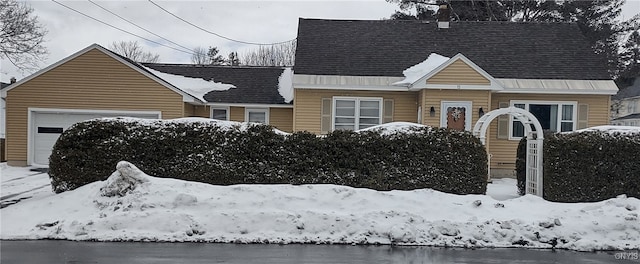 view of front of home with a shingled roof, a garage, and a water view