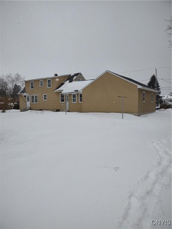 view of snow covered rear of property