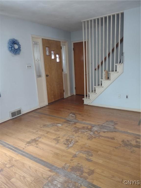 entryway with visible vents, stairway, and wood finished floors