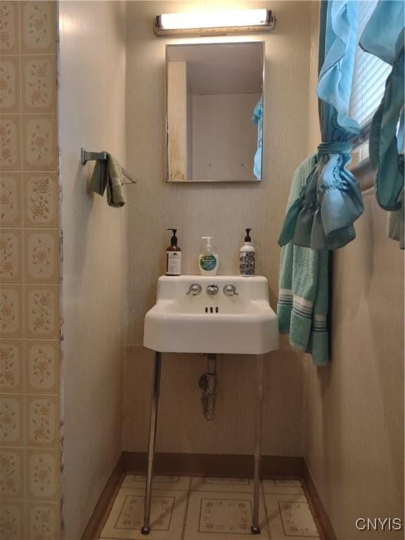 bathroom featuring a sink, baseboards, and tile patterned flooring