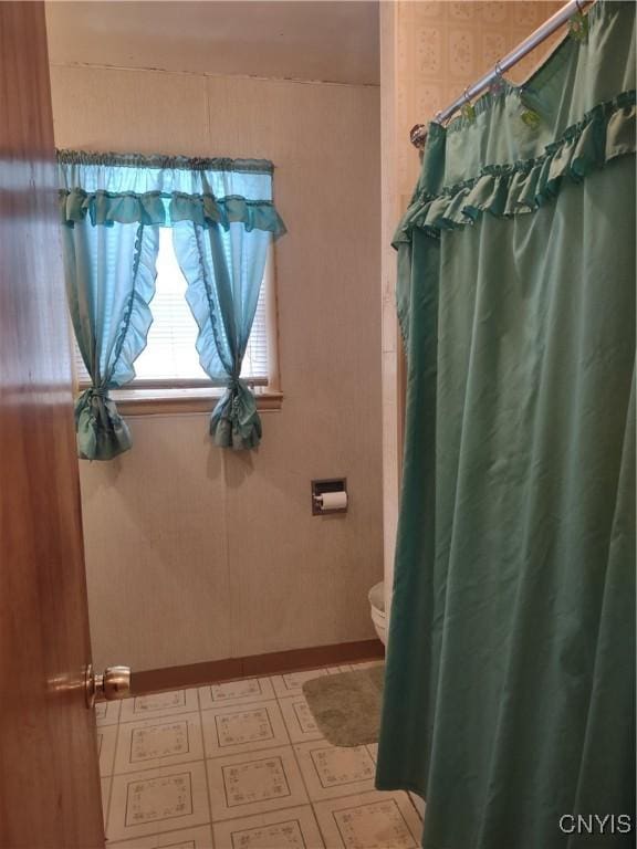 bathroom with tile patterned floors, a shower with curtain, and toilet