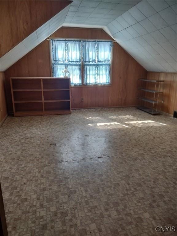 bonus room with vaulted ceiling, wooden walls, and carpet flooring