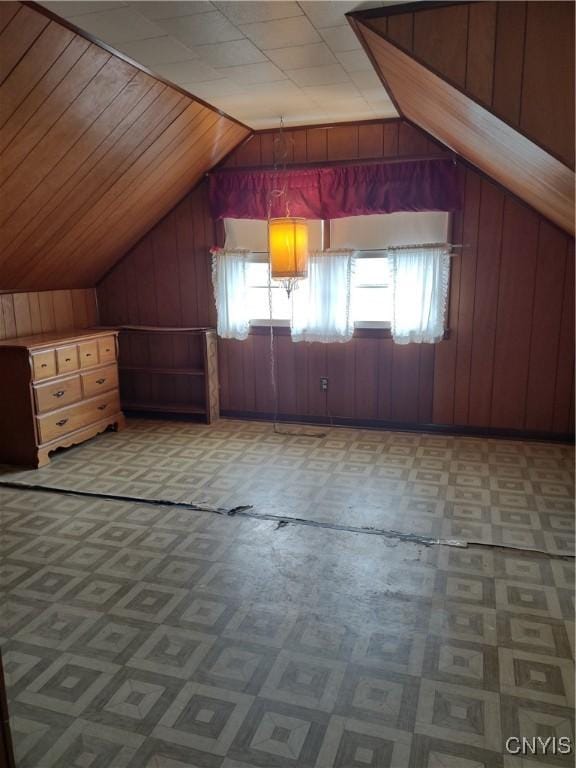 bonus room featuring wooden walls and vaulted ceiling