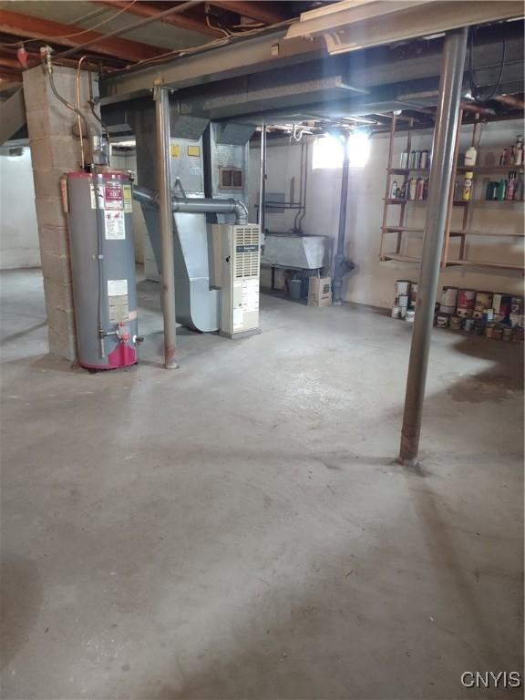 unfinished basement featuring heating unit, visible vents, and water heater