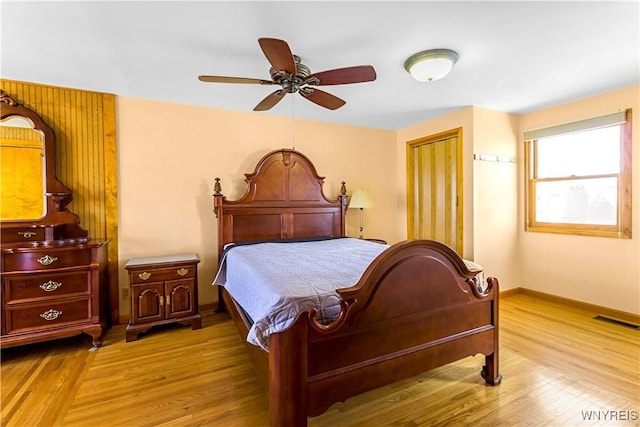 bedroom featuring a closet, visible vents, baseboards, and wood finished floors