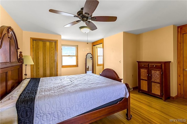 bedroom featuring baseboards, light wood-style floors, and a ceiling fan