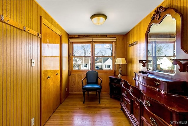 living area with wood walls and light wood-style floors