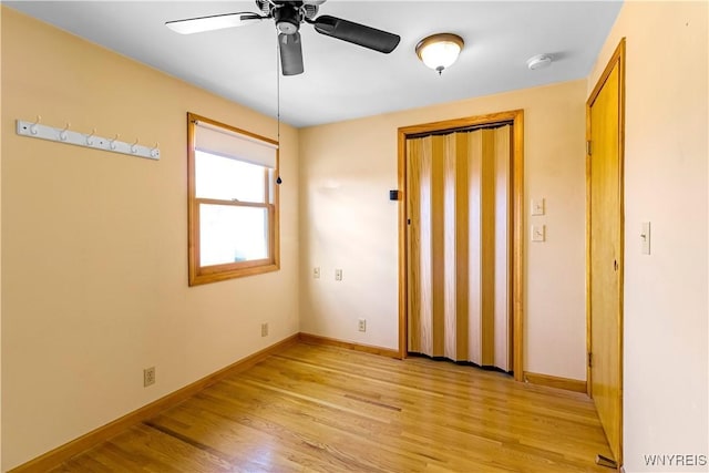 unfurnished room featuring a ceiling fan, baseboards, and light wood-type flooring