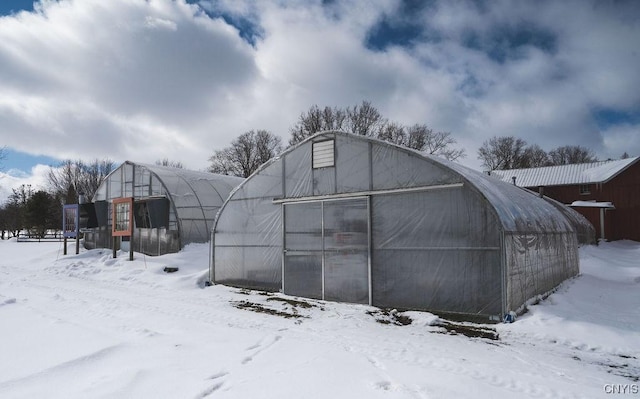 snow covered structure with an outbuilding and an exterior structure