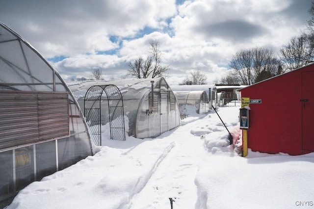 yard layered in snow featuring an outbuilding and an exterior structure