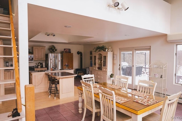 tiled dining area featuring stairs, a wood stove, and a wall mounted AC