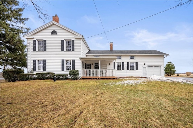 back of property with a yard, an attached garage, a porch, and a chimney