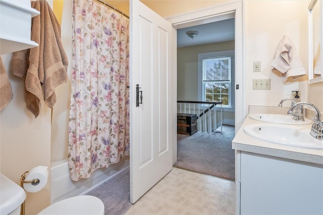 full bathroom with a sink, shower / tub combo, toilet, and double vanity