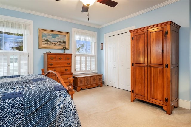 bedroom featuring light carpet, a closet, crown molding, baseboards, and ceiling fan