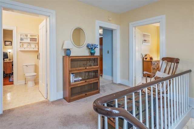 hall featuring carpet flooring and baseboards