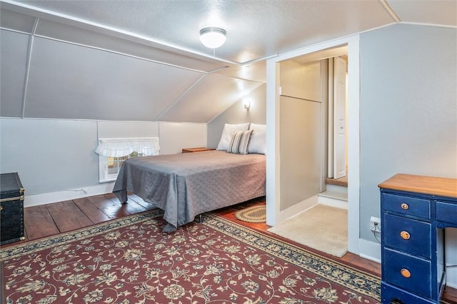 bedroom with lofted ceiling, wood finished floors, and baseboards