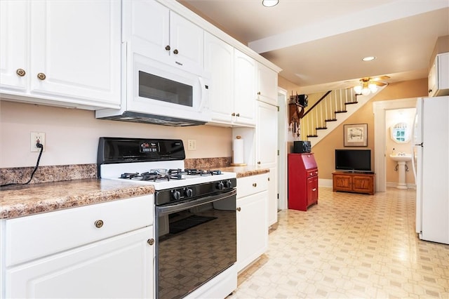 kitchen featuring recessed lighting, white cabinets, white appliances, and light floors