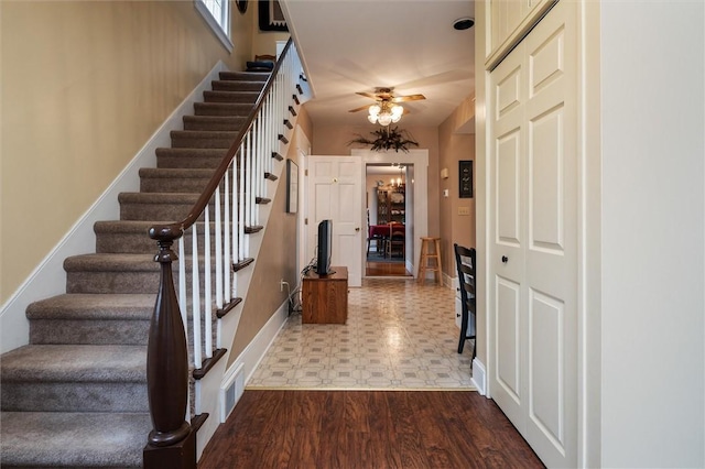 foyer entrance with visible vents, baseboards, stairway, tile patterned floors, and a ceiling fan