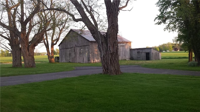 exterior space featuring a barn, driveway, and an outdoor structure