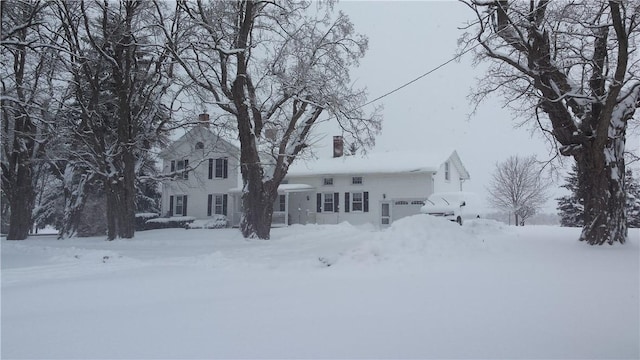 view of front facade with a garage and a chimney