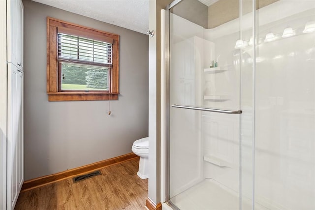 bathroom with visible vents, a stall shower, and wood finished floors