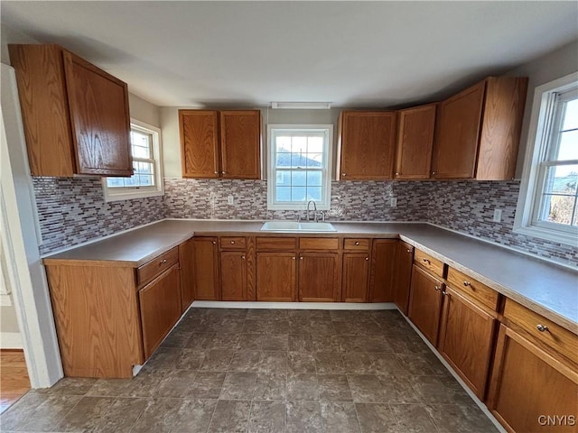 kitchen with a sink, a wealth of natural light, and brown cabinetry