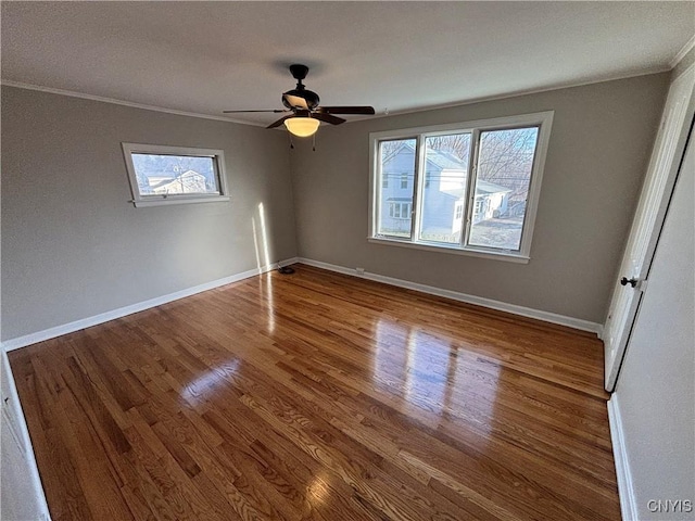 unfurnished bedroom featuring multiple windows, baseboards, and wood finished floors