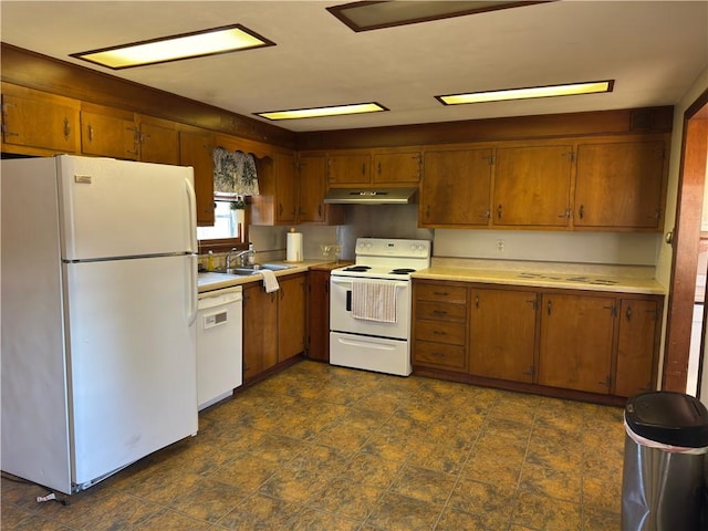 kitchen with white appliances, light countertops, brown cabinets, and a sink