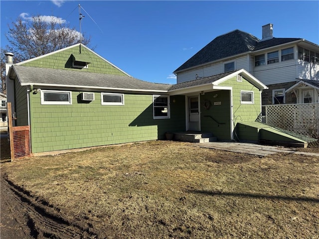 rear view of house with a shingled roof