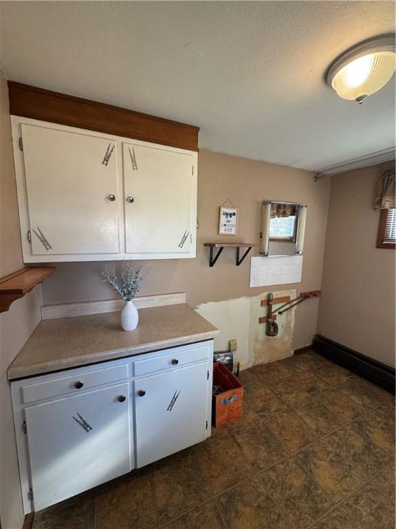 kitchen with white cabinetry and baseboards