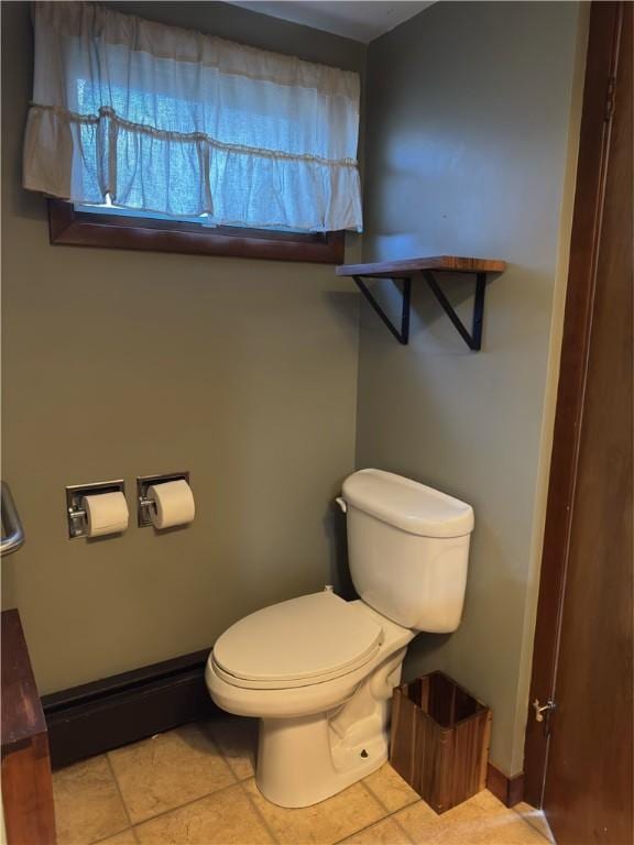 half bathroom featuring tile patterned floors, baseboards, and toilet