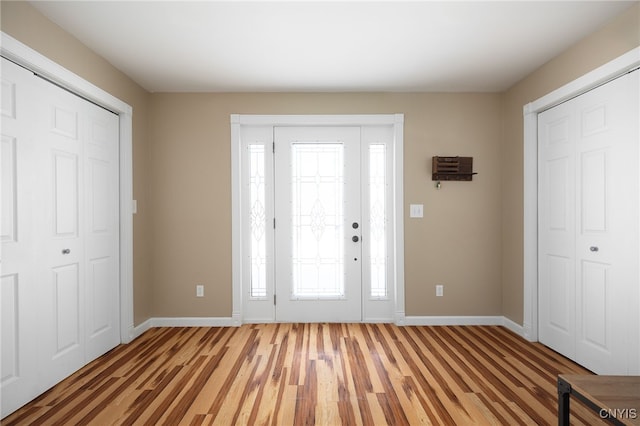 foyer featuring light wood-style flooring and baseboards